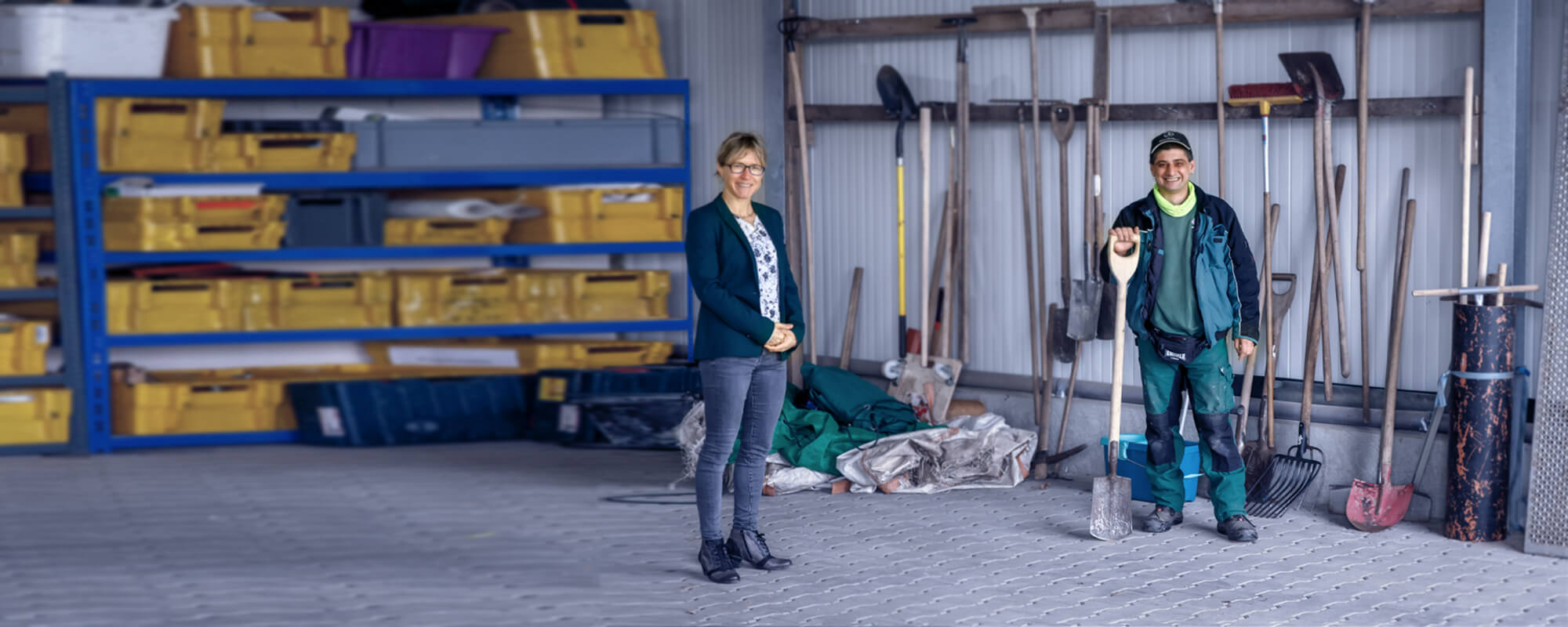 Frau und Mann stehen vor Gartenwerkzeugen und lächeln | © Rupert Oberhäuser Frau und Mann stehen vor Gartenwerkzeugen und lächeln