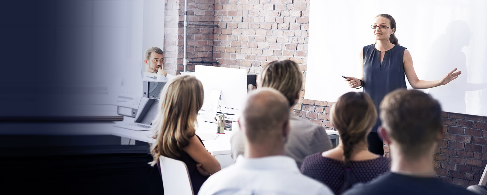 Dozentin hält ein Seminar ab | © Shutterstock / Rawpixel.com Eine Dozentin steht vor einer weißen Tafel und hält ein Seminar ab